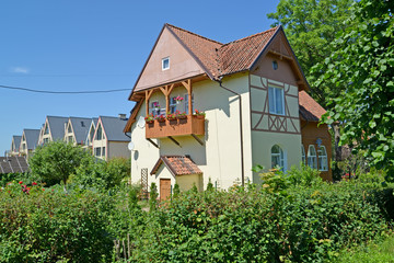 Fototapeta na wymiar Cottage with a balcony in summer day. Settlement Amber, Kaliningrad region