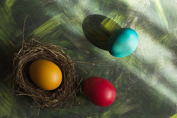 Three multi-colored Easter eggs on a motley background.