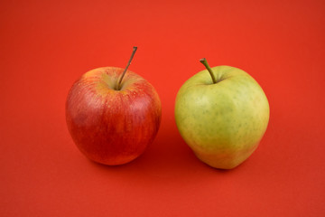 Red and green apple stock images. Apples on a red background. Two ripe apples. Red and green apples isolated on a colorful background