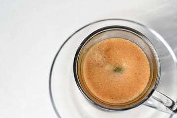 Espresso. Glass espresso cup with coffee beans on a light background