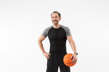Portrait of a happy mature sportsman holding basketball