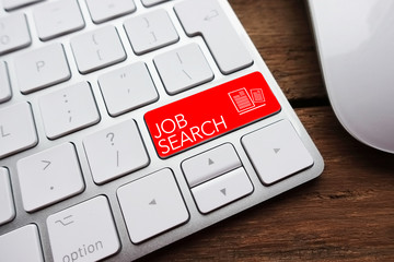 Online job search concept with computer keyboard and red text on enter key
