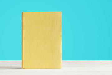 book with blank yellow cover with a blue background.