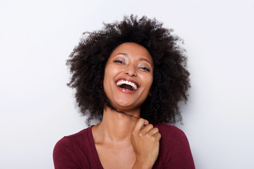 Close up cheerful young african woman with hand in hair and laughing