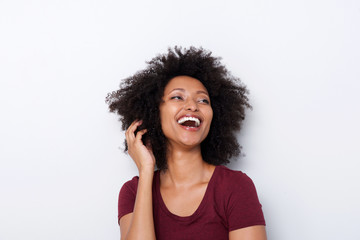 Close up cheerful young black female looking away and laughing against white background