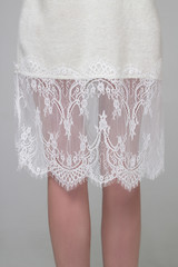Close-up of female white skirt with wide laces