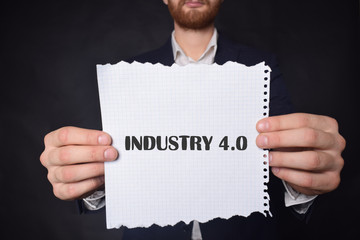 In the hands of a businessman a scrap of paper with the inscription:INDUSTRY 4.0
