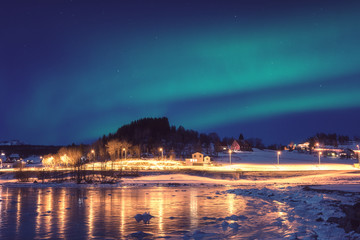 Naklejka na ściany i meble Northern lights, Aurora borealis in night sky over Gausvik, Lofoten Islands, Norway. Scenic winter landscape