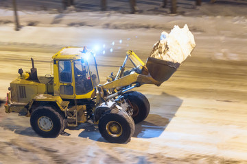 loader removes snow in the night