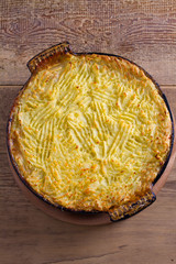 Shepherd pie - popular dish in Ireland. Beef meat, mashed potato, cheese, carrot, onion and green peas casserole in baking dish. View from above, top