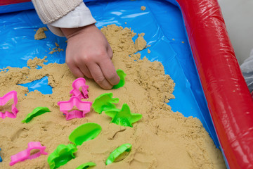 kid playing sand and plastic moulds