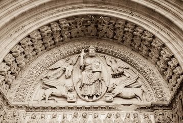 Church of St. Trophime in Arles. Jesus Christ surrounded by Four Evangelists (represented as winged man, lion, ox and eagle) and angels above entrance to church. Provence, France. Sepia historic photo - obrazy, fototapety, plakaty