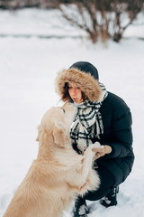 Photo of labrador giving paw to girl in winter park