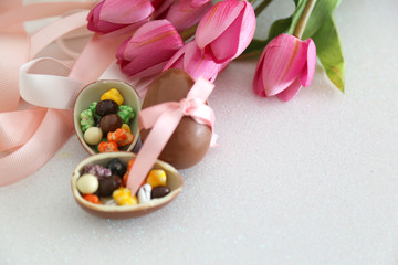 Easter composition with chocolate eggs on color white  background,