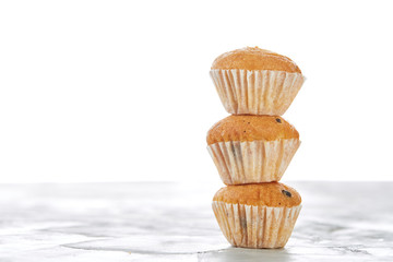 Tasty muffins arranged in pattern on light textured background, close-up, shallow depth of field, selective focus.