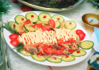 meat salad with pomegranate seeds at the Christmas table