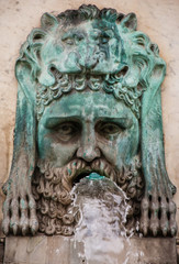 Fototapeta na wymiar Fountain with mythological bronze lions at the square in front of the city hall of Arles. Provence, France. Architectural detail.