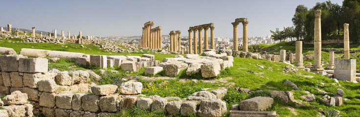 Fototapeta premium panorama of ruins with columns in old city in spring day in Jordan