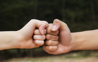 In selective focus of the hands fist bump or power five is the gesture of giving respect or...
