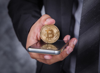 close up business man with bitcoin and using mobile phone