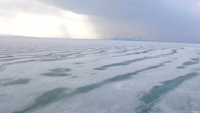 Flying over iced sea or lake by helicopter .