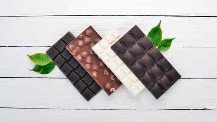 Dark and milky white chocolate on a wooden table. Top view. Copy space for text.