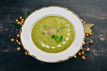 Soup with broccoli and peas and vegetables in a bowl. Healthy food. On a black wooden background. Top view. Copy space for your text.