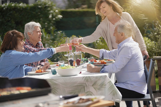 Senior People Gathering For Summer Barbecue Lunch