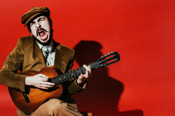 positive guy playing guitar in the Studio