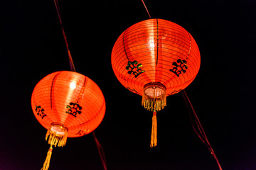 a couple of red Chinese paper lanterns all lit up for Chinese New Year