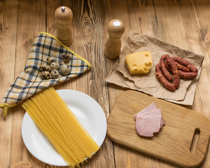 Ingredients for Italian pasta. Raw spaghetti, ham, spices.