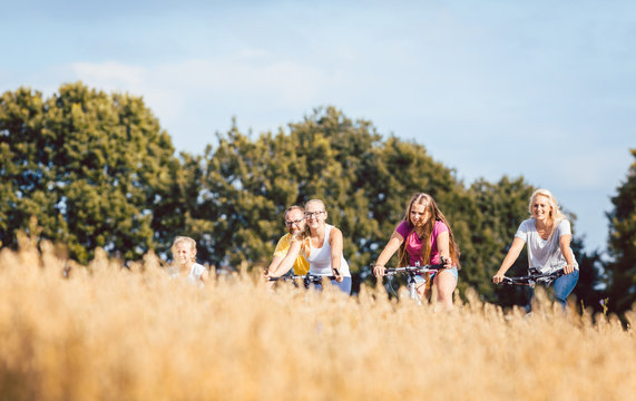 Familie fährt Fahrrad im Sommer an einem Getreidefeld