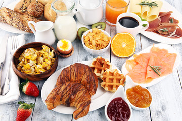 breakfast on table with waffles, croissants, coffe and juice