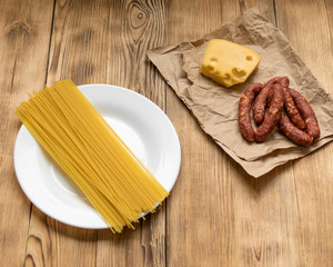 Ingredients for Italian pasta. Raw spaghetti, ham, spices.