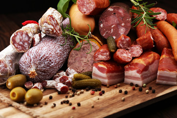 Food tray with delicious salami, ham,  fresh sausages, cucumber and herbs. Meat platter