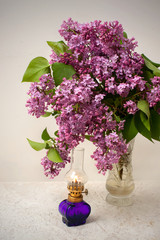 romantic bouquet of lilacs in crystal vase and a gas lamp