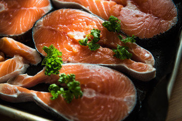 the fresh fish stakes with greens which are laid out on a baking sheet sunlight