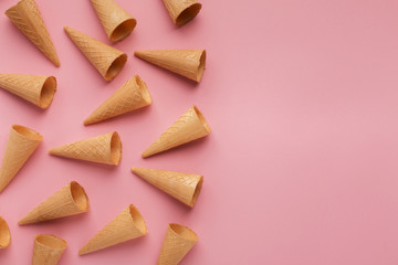 Waffle ice-cream cones on pink surface