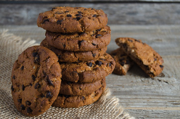Chocolate chip cookies. Burlap and old wooden table.