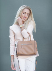 Beautiful business lady in the city. Professional make-up and blond hair. Summer shot.