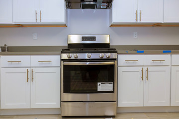 Fototapeta premium Installation of kitchen installs kitchen cabinet. Interior design construction kitchen