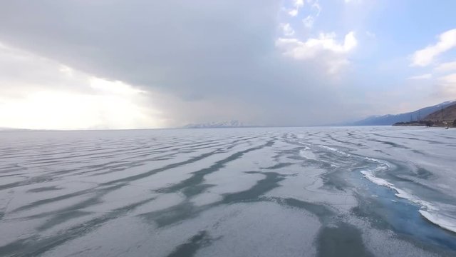 Flying over iced sea or lake by helicopter .