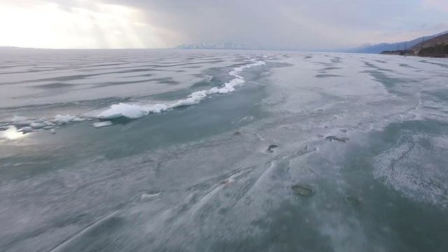 Flying over iced sea or lake by helicopter .