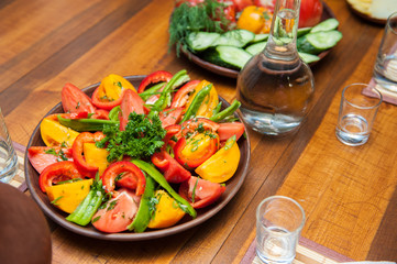 Multi-colored fresh cutted vegetables on a wooden plate