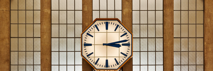 Retro clock on the wall of the railway station, panoramic photo