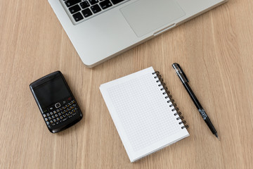 laptop with pen on desk and phone