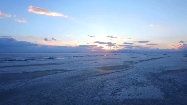 Flying over iced sea or lake by helicopter .