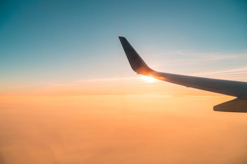 Fototapeta premium aircraft wing with sunset sky,scenic outside windows,sunnet in the air,looking through aircraft window.
