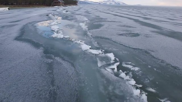 Flying over iced sea or lake by helicopter .