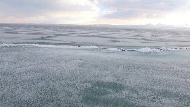 Flying over iced sea or lake by helicopter .